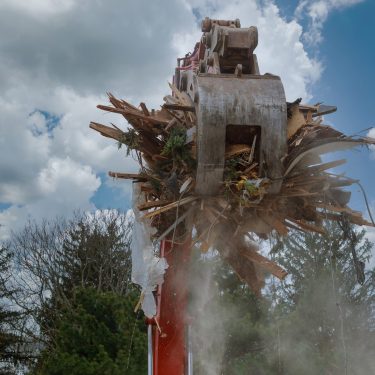 Dismantling an old house, bulldozer destroys of the demolition of a building under construction of a new house.